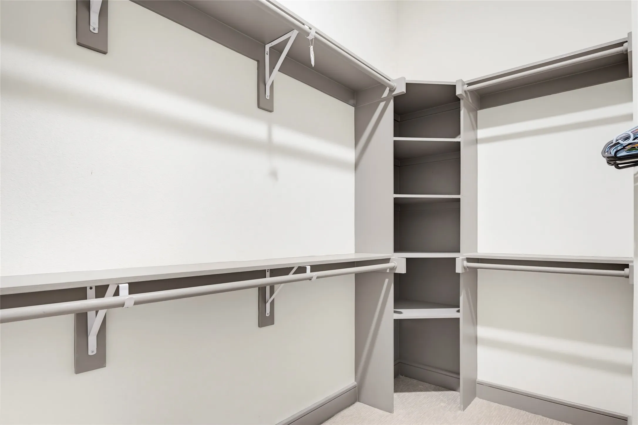 Custom closet organization system with ample shelving and hanging rods
