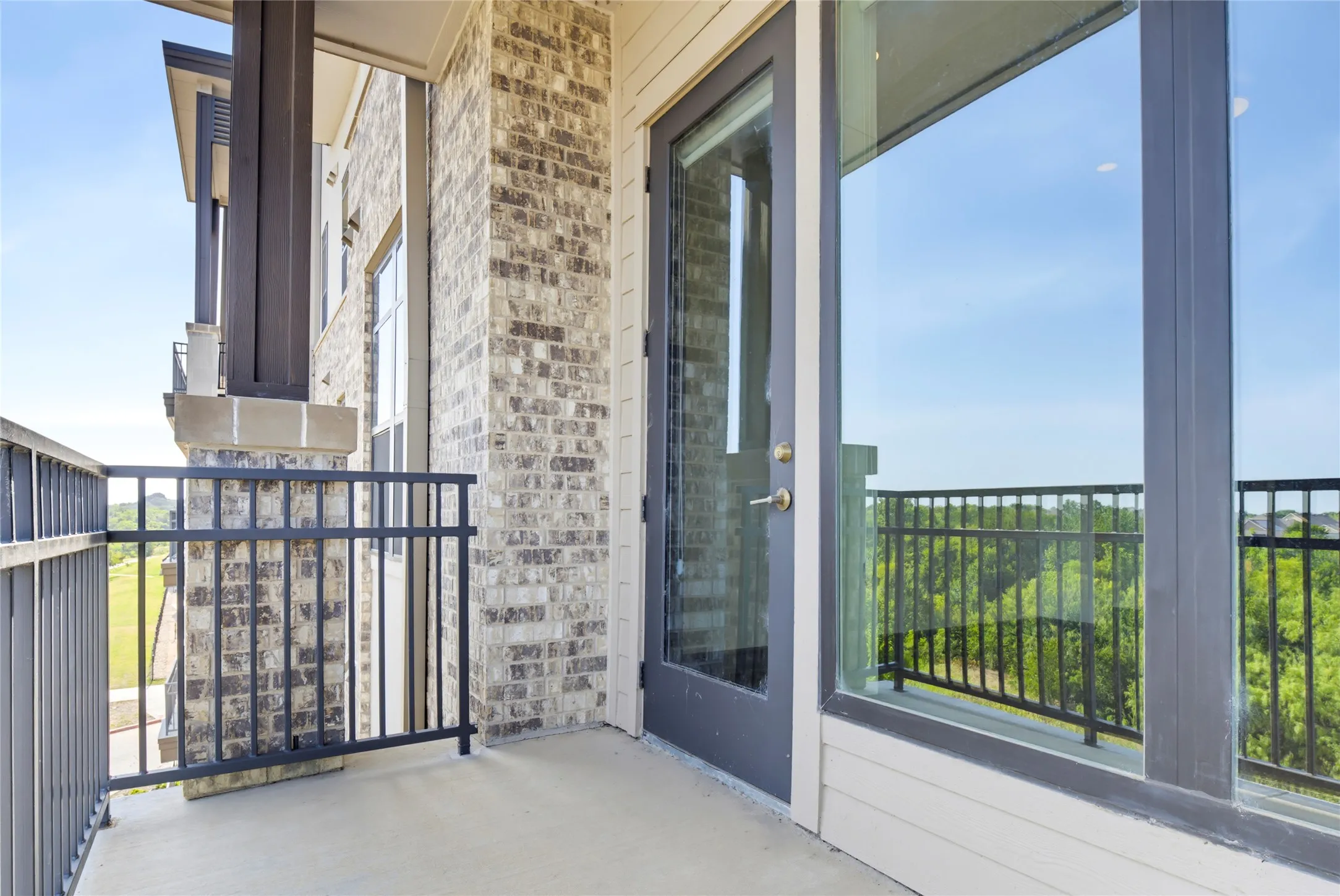 Balcony featuring concrete flooring and black metal railing