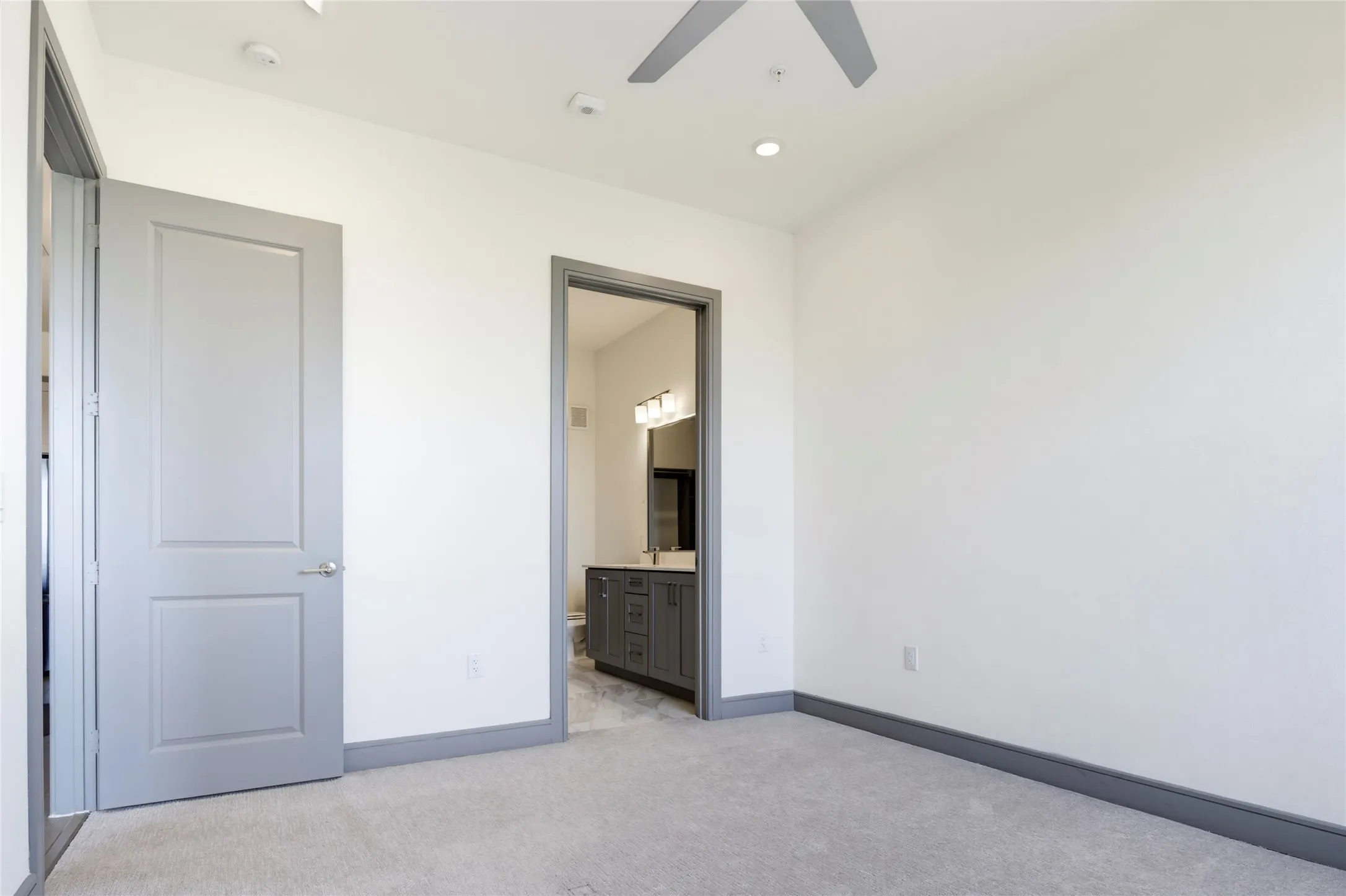 Recessed lighting, ceiling fan, grey carpeting, and grey trim