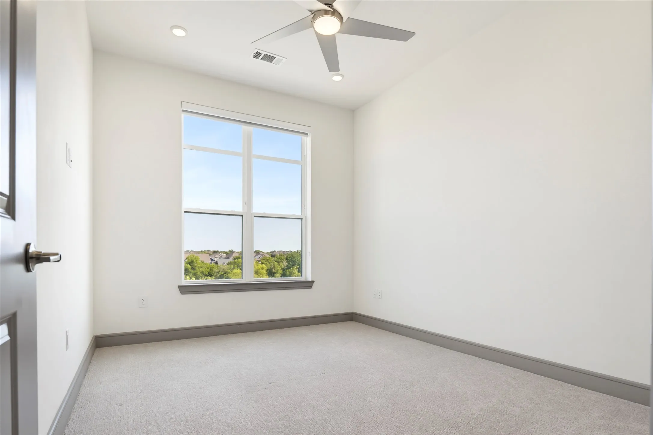Recessed lighting, ceiling fan, white walls, gray baseboards, and light-colored carpeting