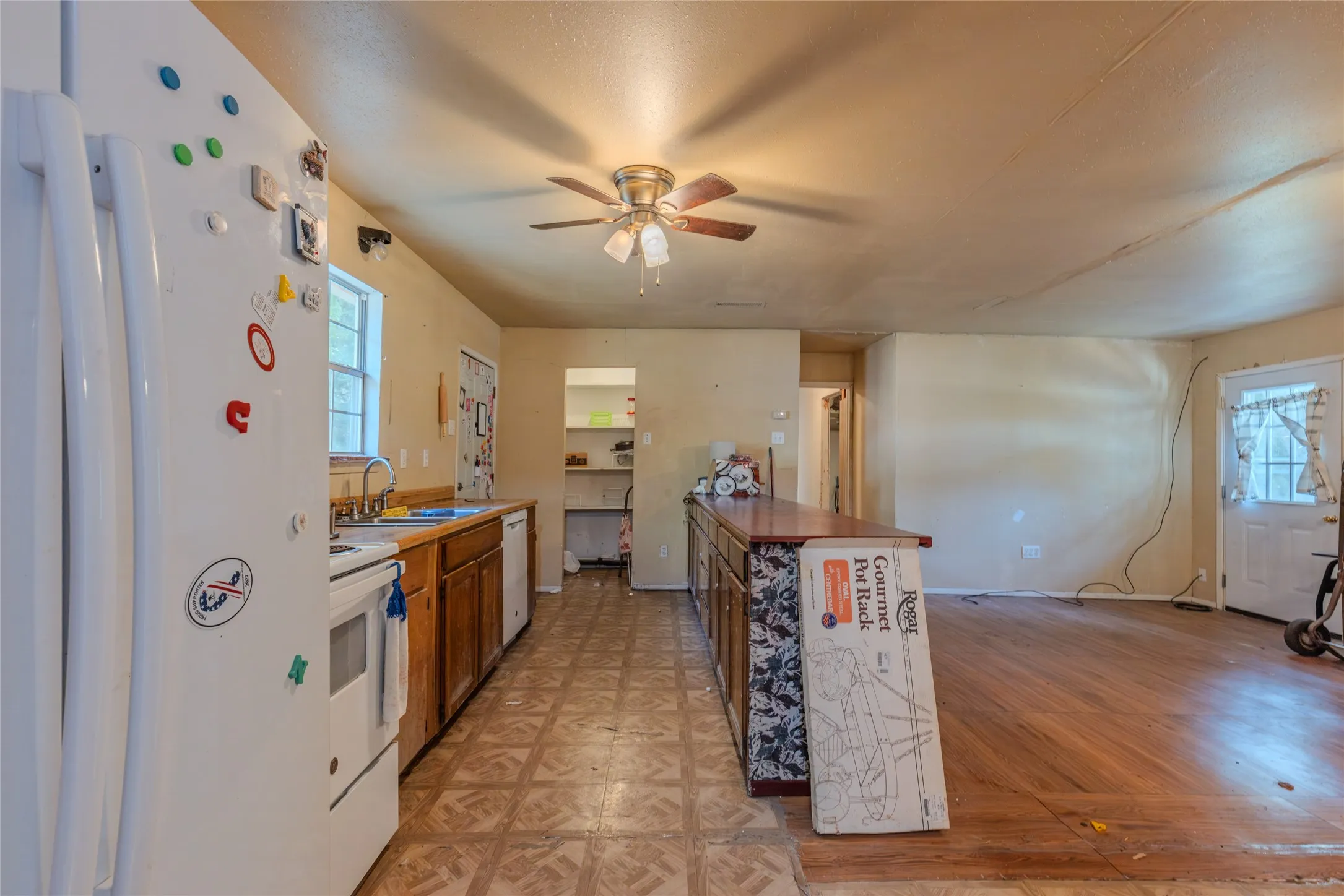 Kitchen with wood-finish cabinetry, white appliances, and a central island