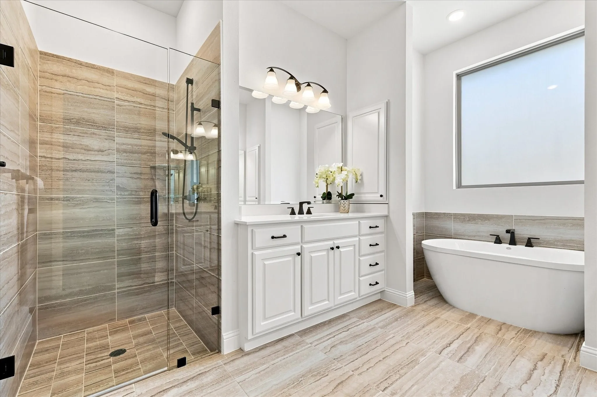 This primary bath has all you could want with a large walk-in shower, soaking tub, and two sink vanities.