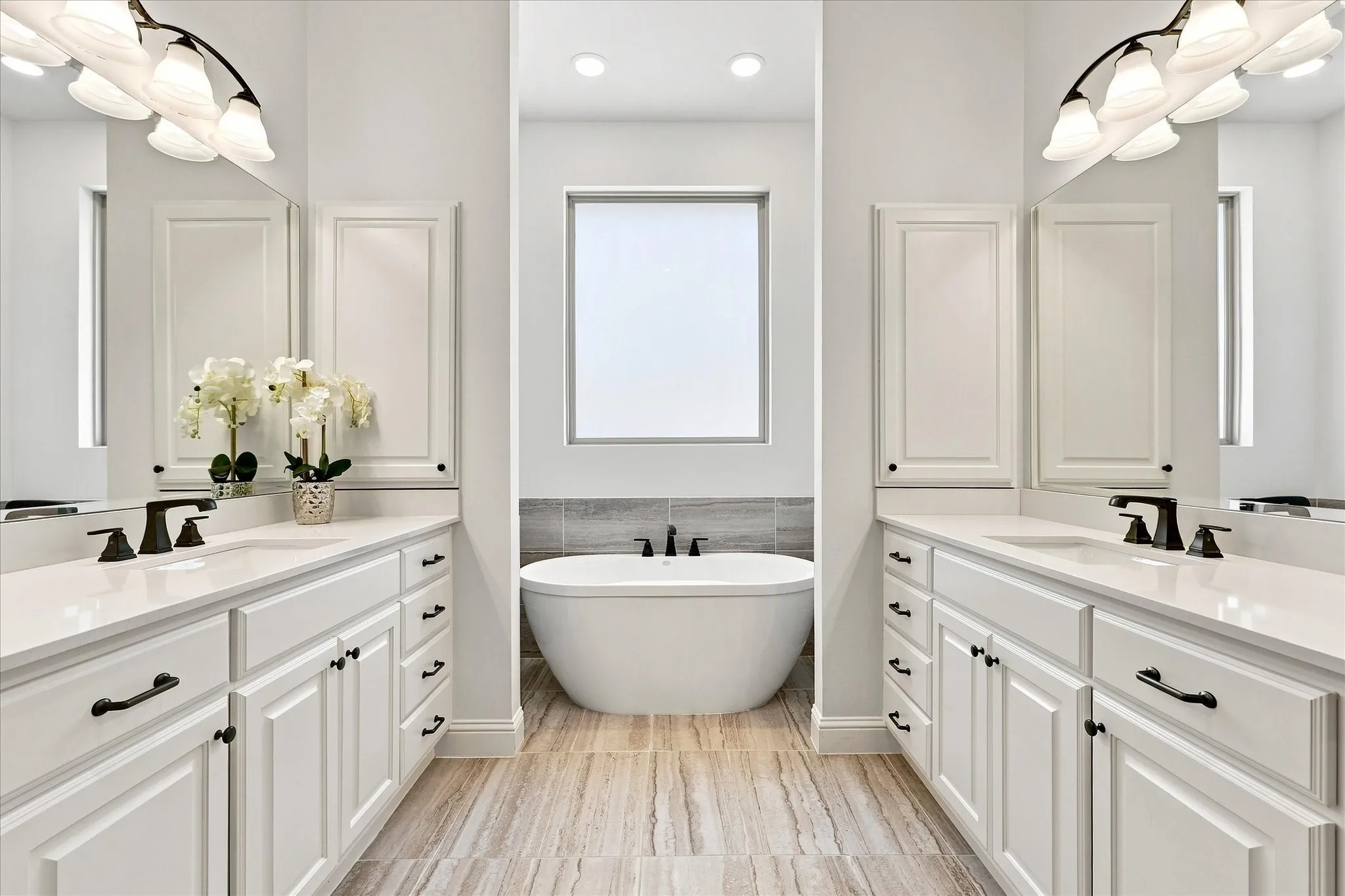 The symmetry is so pleasing.  Note the vanity cabinet and drawer storage as well as the built-in medicine cabinets.  The obscure glass above the tub lets in light while giving privacy.