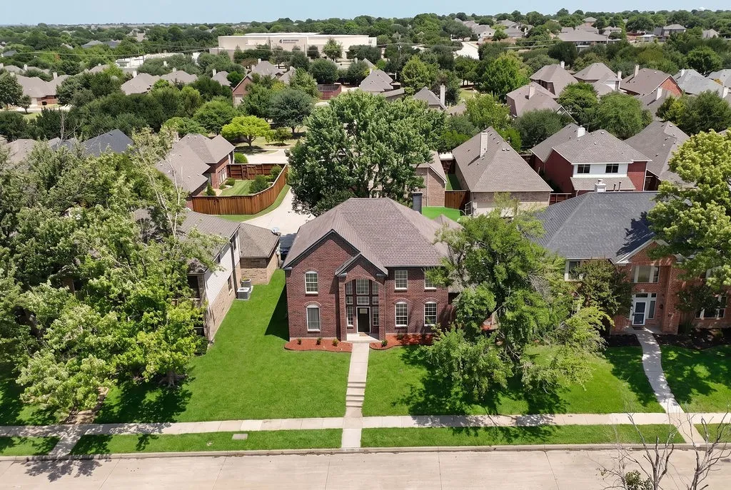 Two-story brick facade residence featuring a front gabled roof and a well-maintained lawn