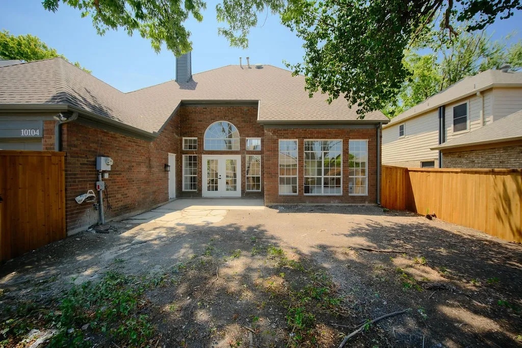 Brick exterior with arched entryway, multi-pane glass doors and windows, and a circular window detail