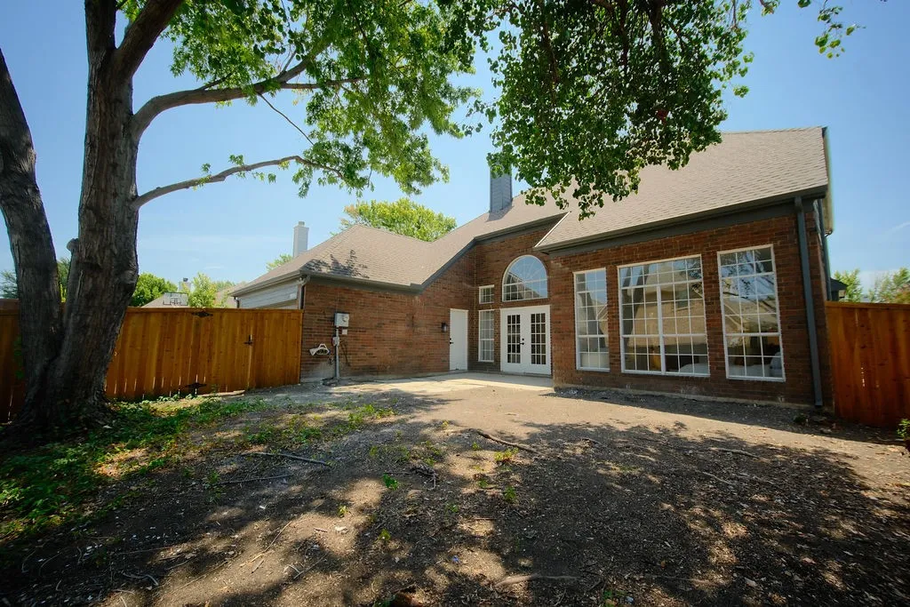 Brick exterior with multiple large windows, a white double-door entrance, and an arched transom window