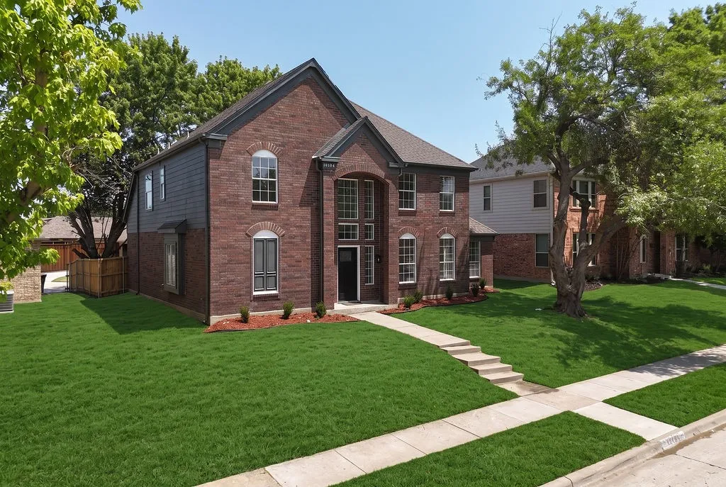 Elegant brick Colonial with distinctive architectural details, including arched entryway and multi-pane windows