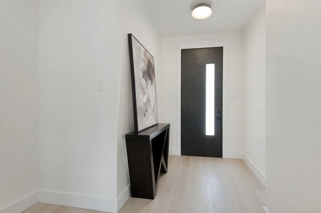 Wood-finish flooring, white walls, and a modern ceiling light fixture