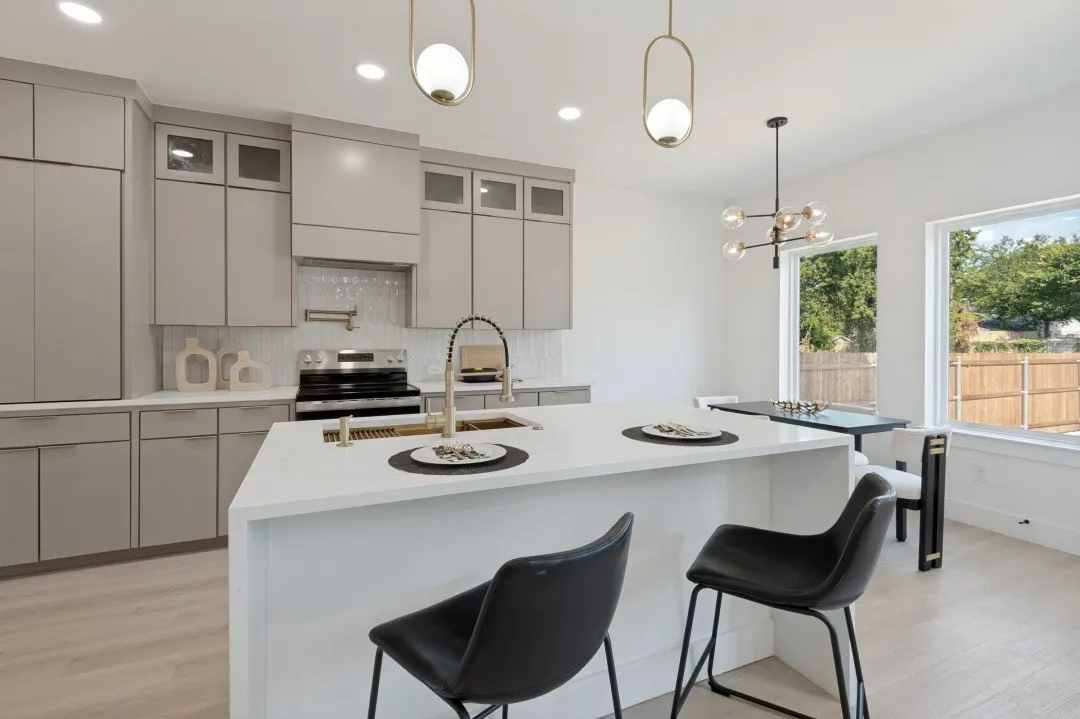 Contemporary kitchen featuring light gray cabinetry, a white countertop island, and wood-finish flooring