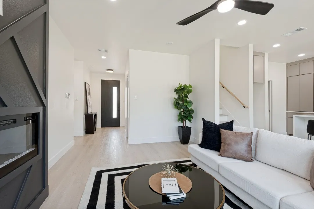 Open-concept living area featuring light wood-finish flooring, recessed lighting, and a modern ceiling fan
