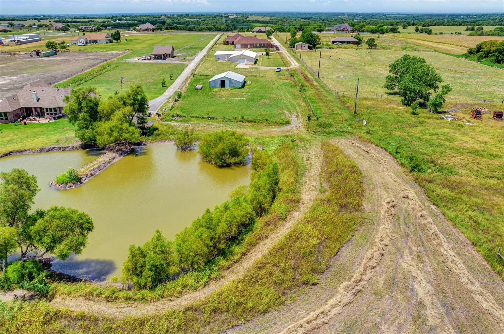Expansive parcel featuring a large pond with an island, surrounded by mature trees