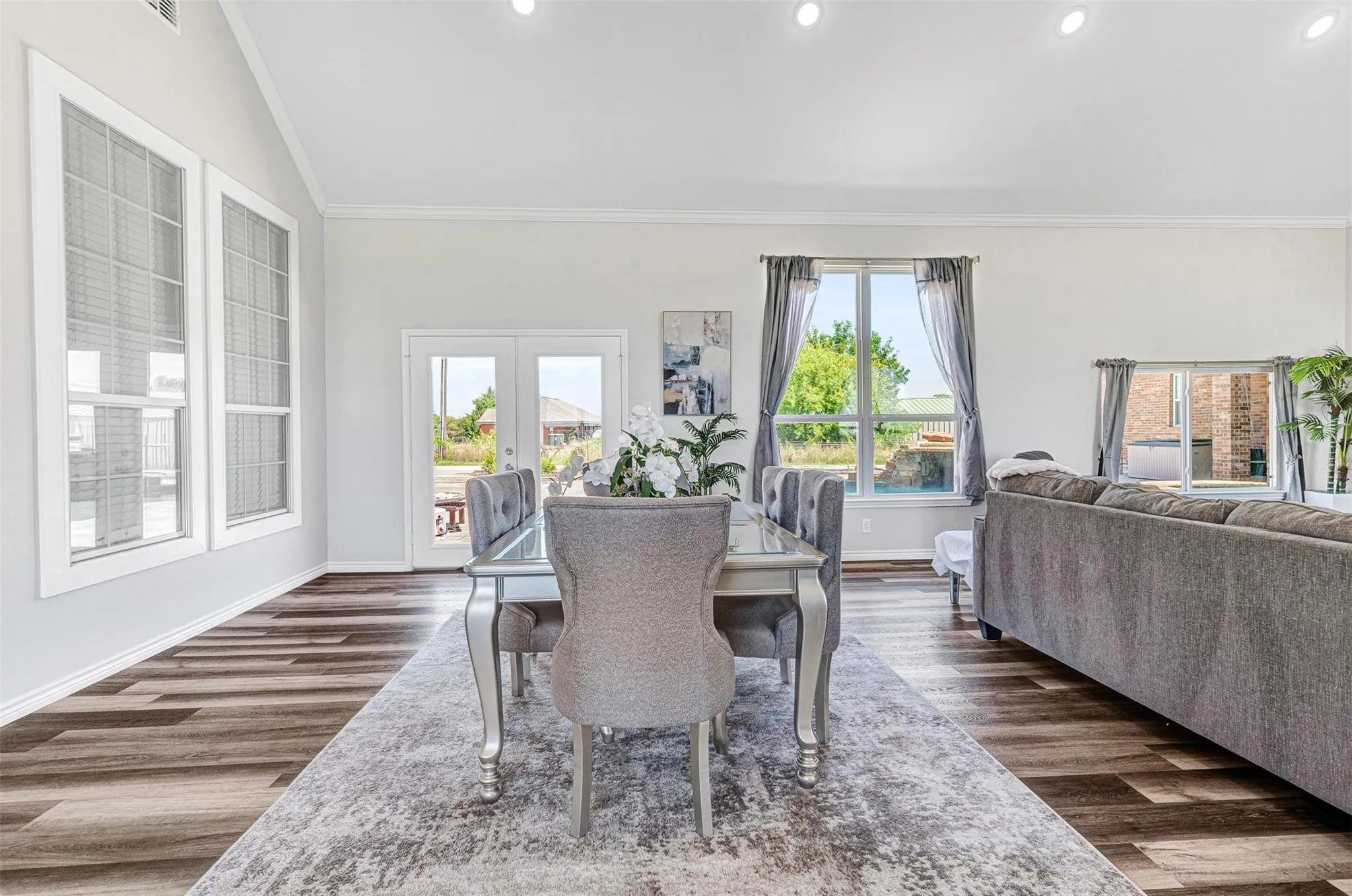 Bright, open living area showcasing hardwood flooring, expansive windows with natural light, and neutral wall finishes