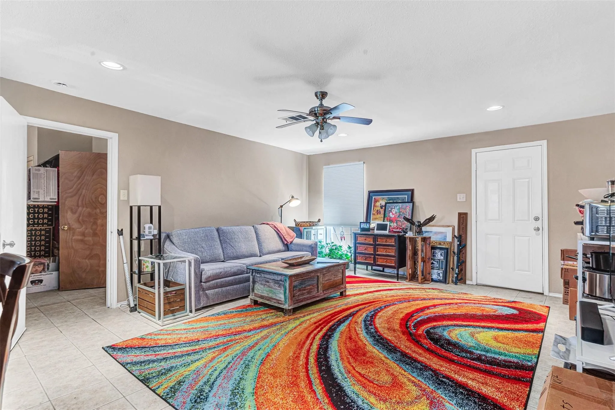 Recessed lighting, ceiling fan, neutral wall tones, tiled flooring, and a white paneled door
