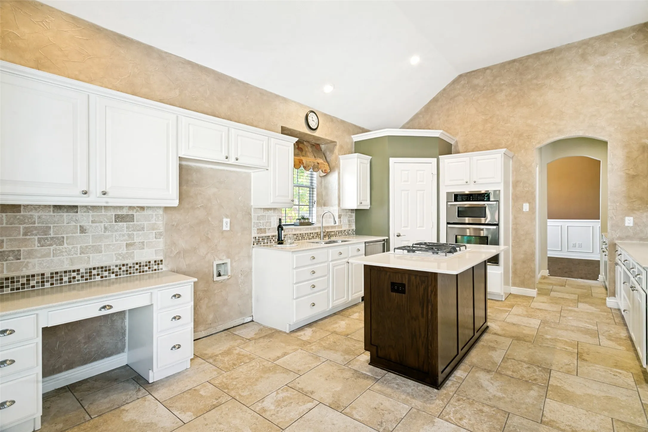 Kitchen including desk and island with glimpse of dining room