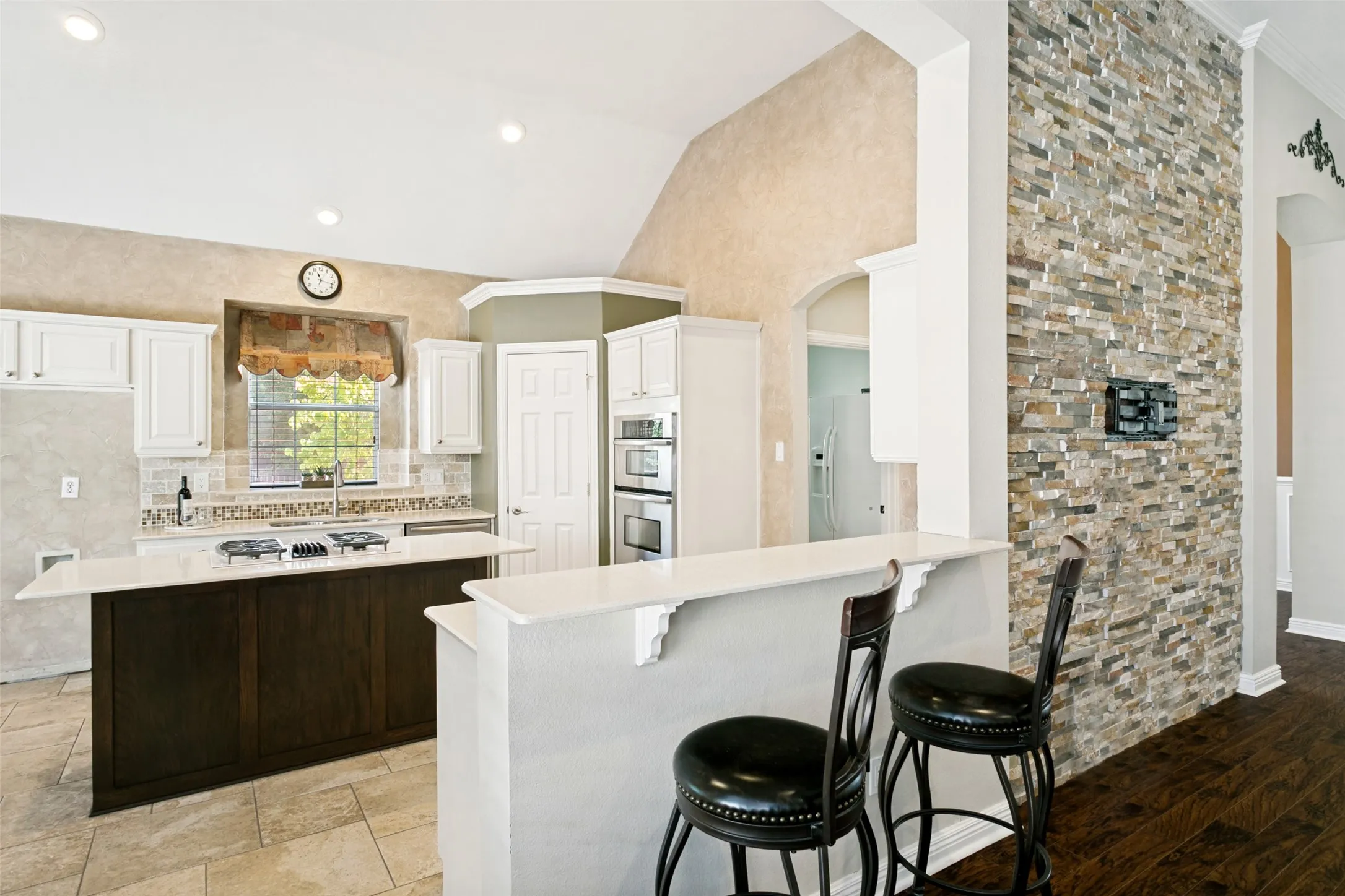 Stacked stone wall and breakfast bar overlooking kitchen