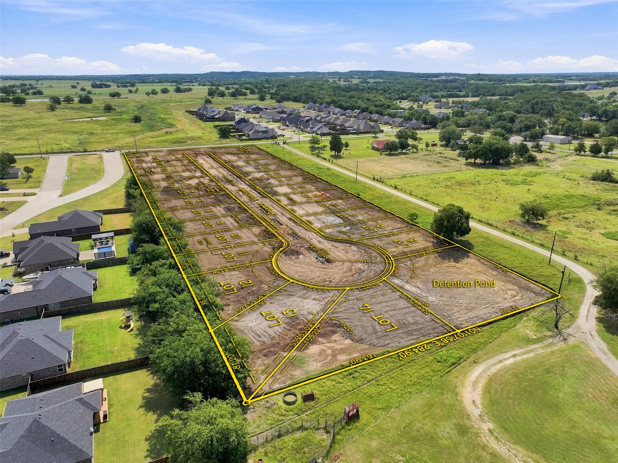 Platted residential lots with a cul-de-sac design, surrounded by green spaces and existing residences