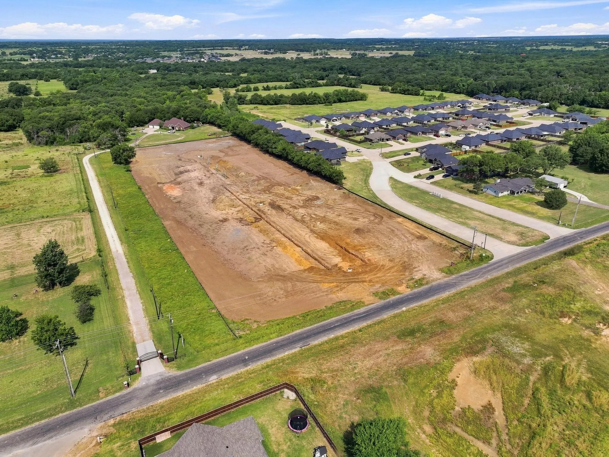 Expansive open lot featuring cleared land and surrounding mature trees