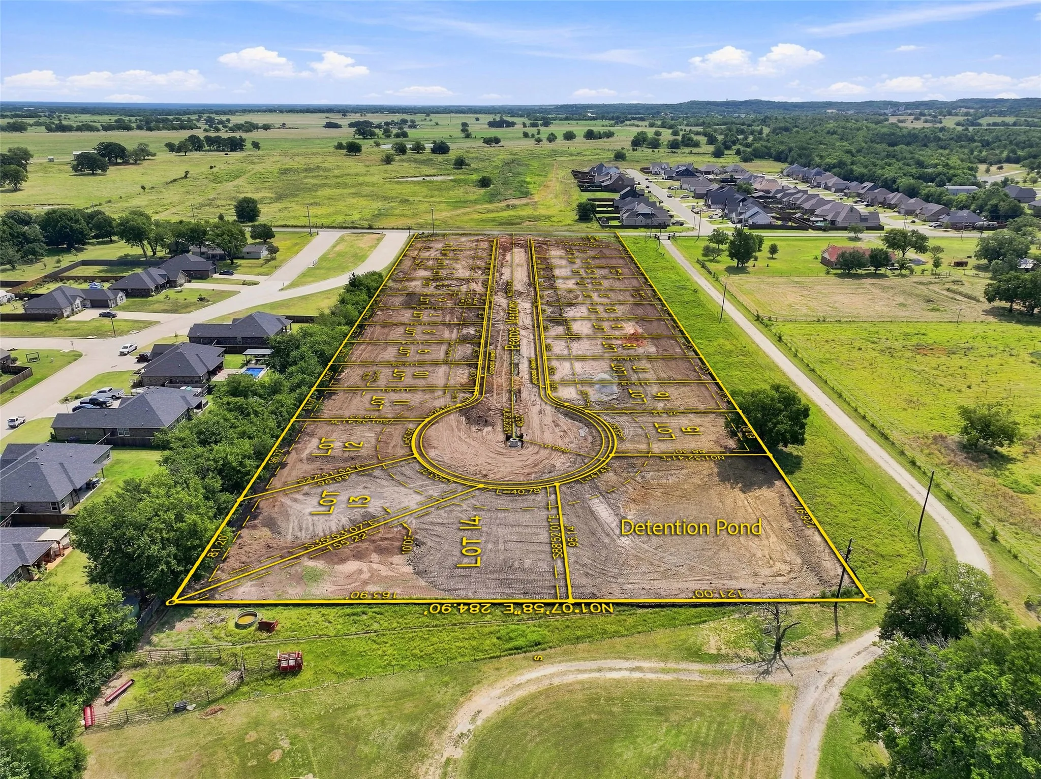 Expansive residential development lot featuring approximately 10+ acres of cleared and graded land with defined home sites, internal road infrastructure, and pond