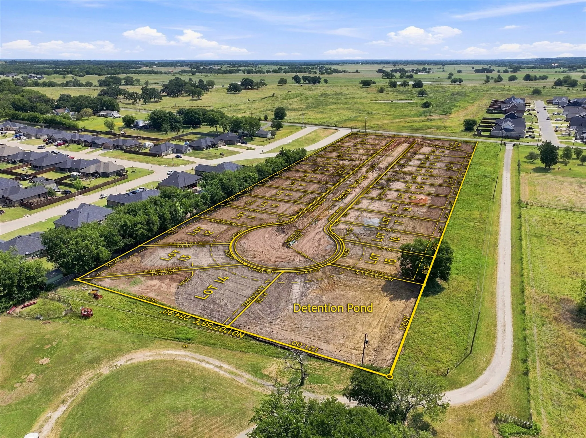 Expansive equestrian property featuring a professionally designed arena with decorative patterns, multiple paddocks with organized pasture sections, a stocked pond, tree-lined perimeter, and direct access via paved driveway