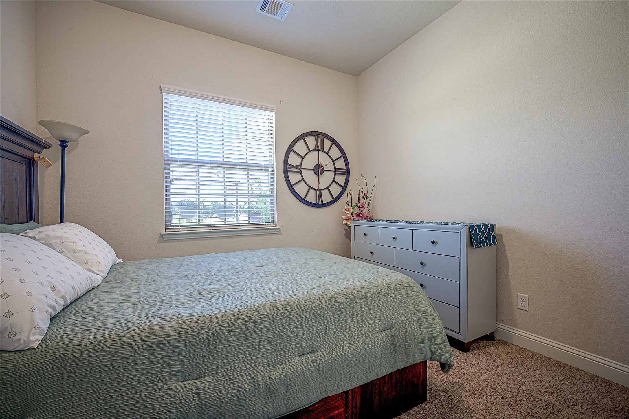 Warm wall color, window with blinds, and durable carpet flooring