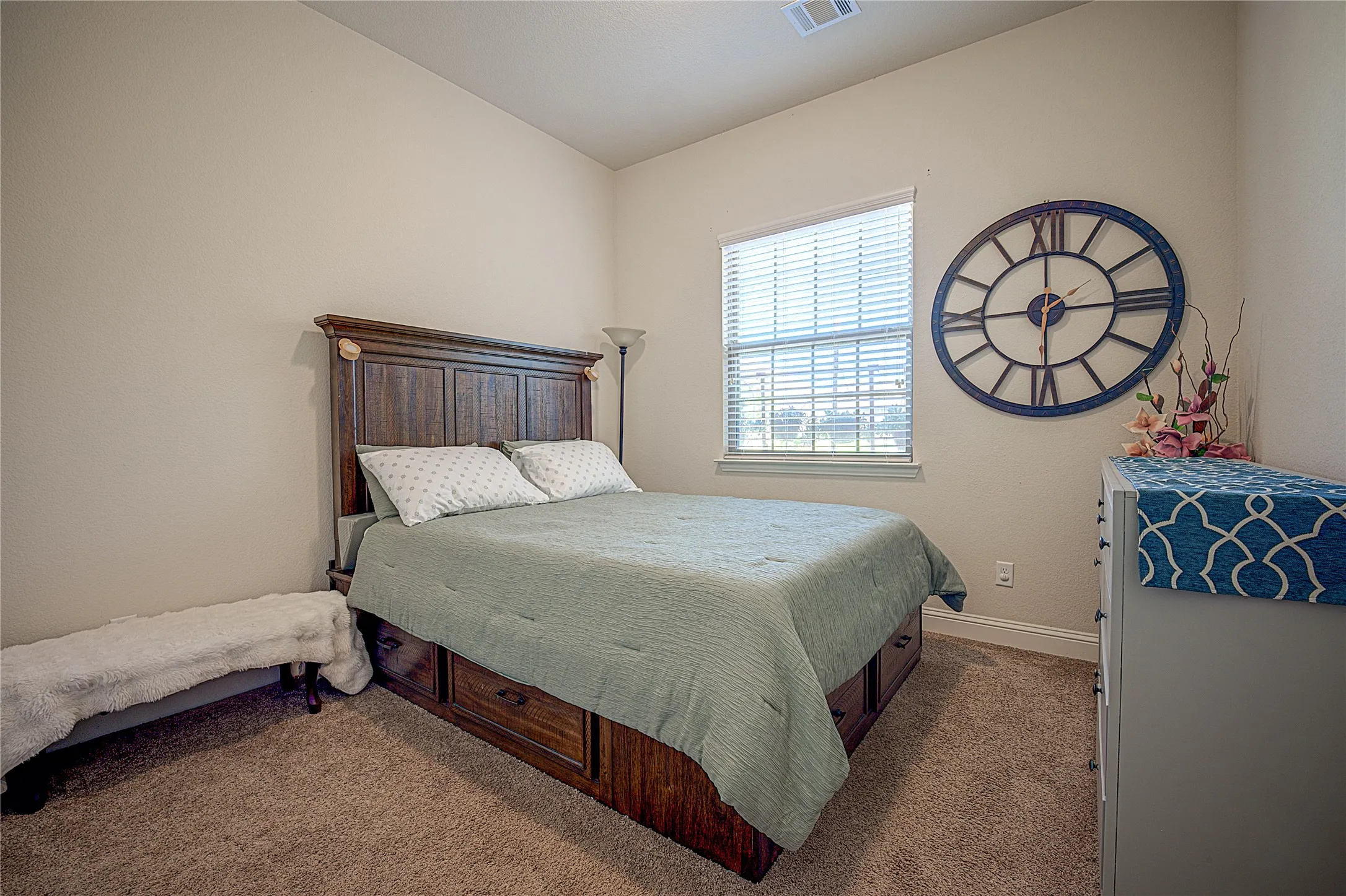 Light-colored walls, vaulted ceiling, single window with blinds, and neutral carpet flooring