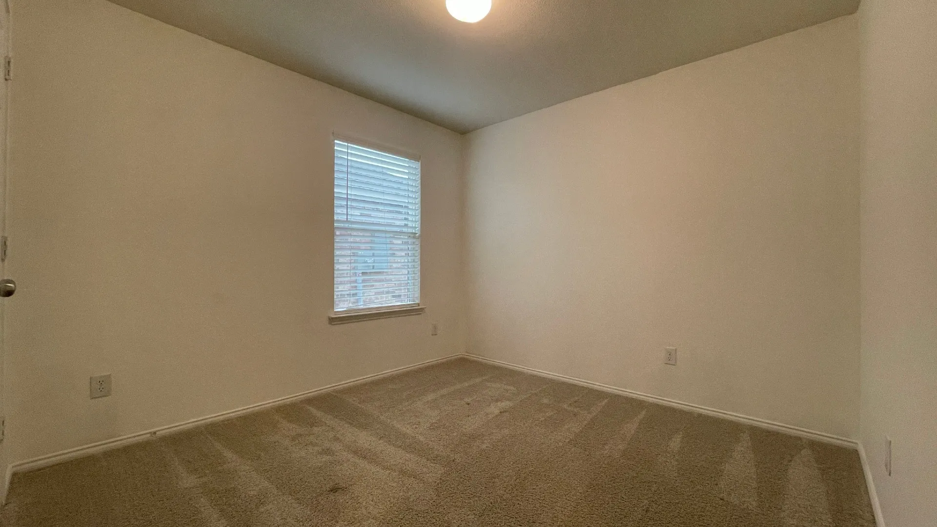 Bright secondary bedroom featuring neutral wall finishes, recessed ceiling lighting, and carpeted flooring throughout