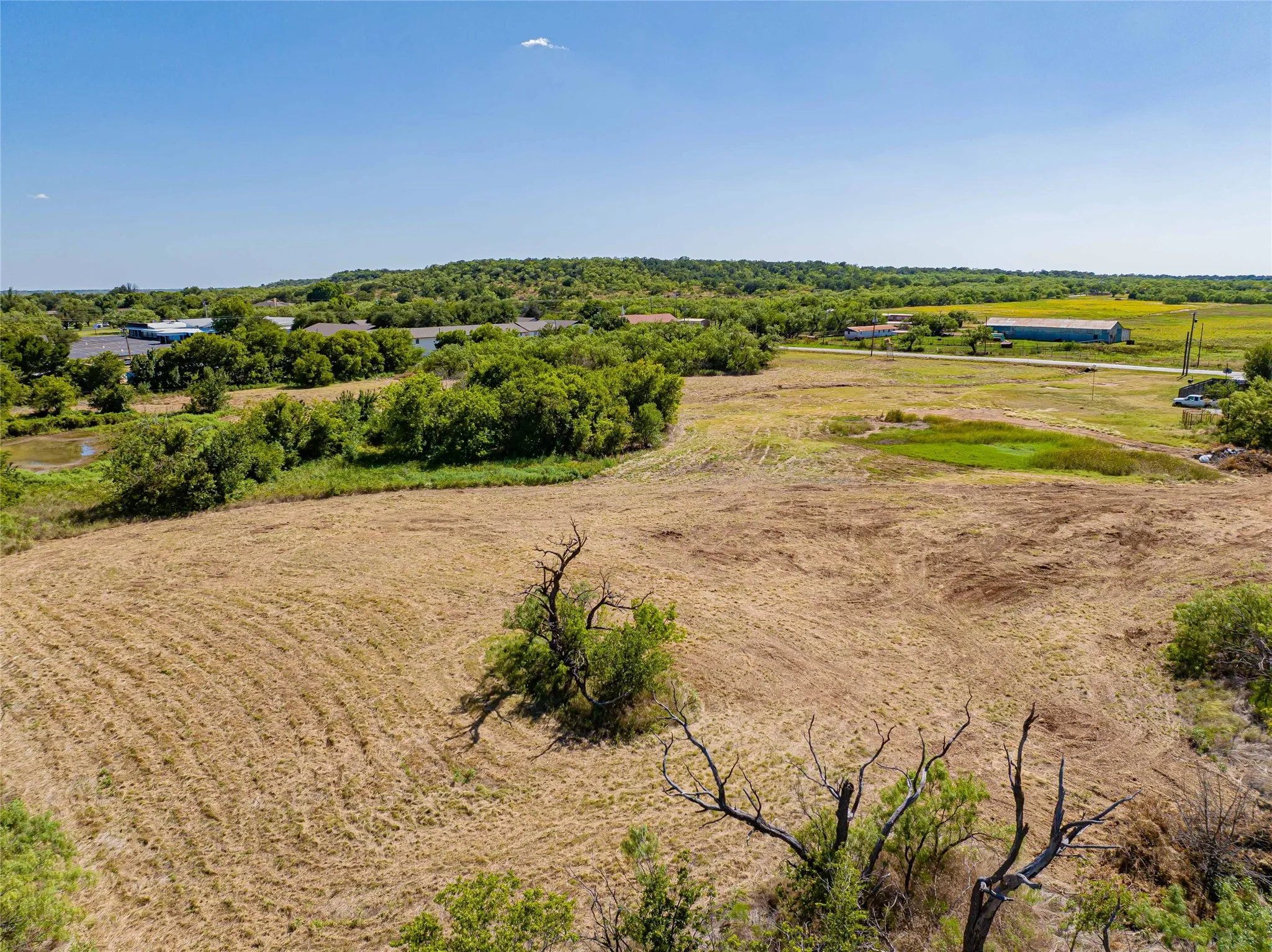 Expansive rural acreage featuring productive agricultural land with mature tree groves, open pasture areas, and established landscaping