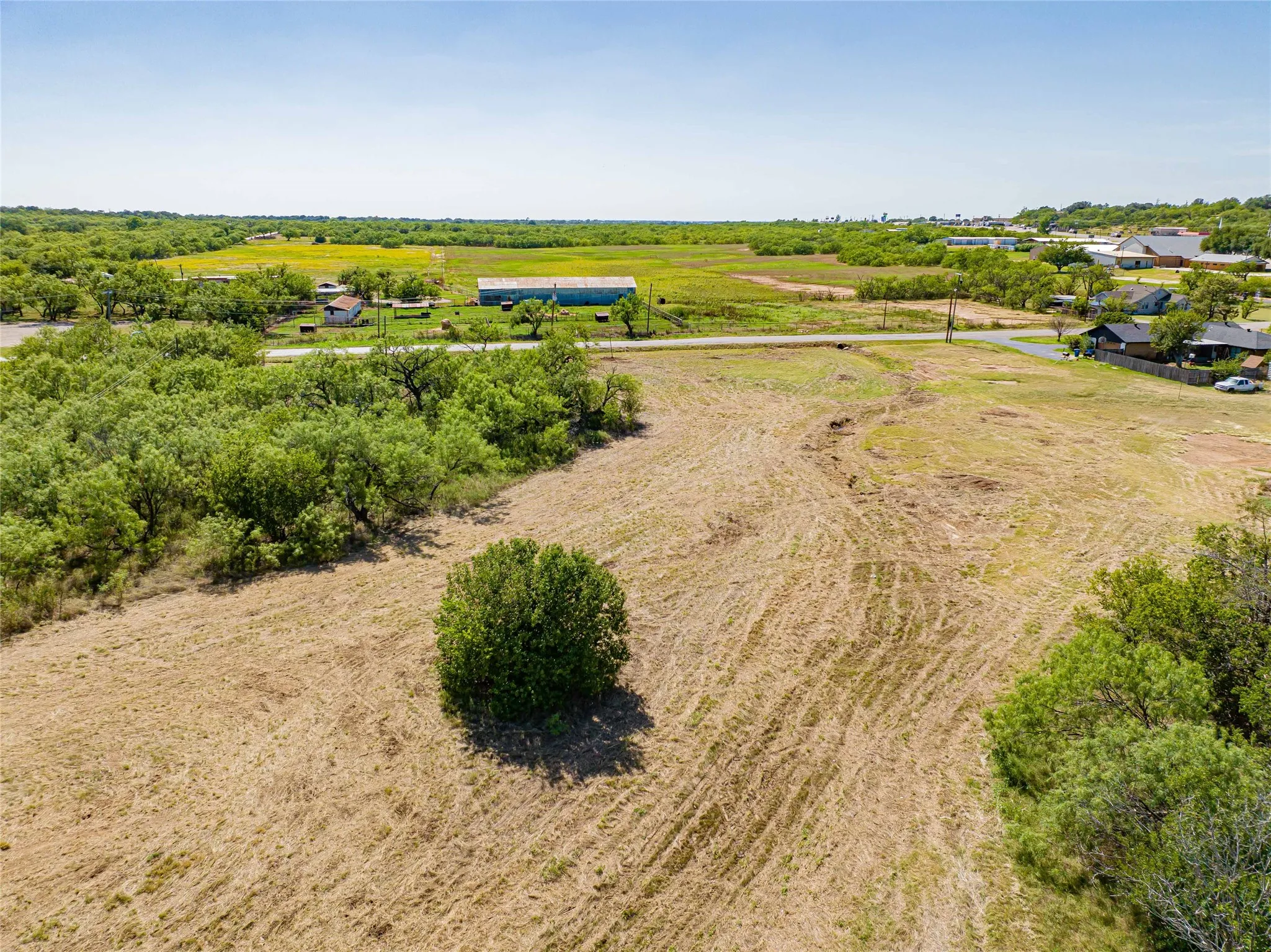 Expansive rural acreage featuring cleared and cultivated grounds with mature tree clusters throughout