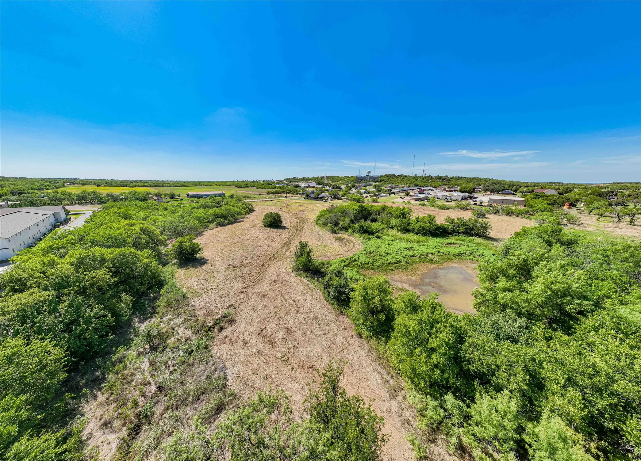 Expansive rural acreage featuring mature tree clusters, open pastureland, and natural drainage patterns