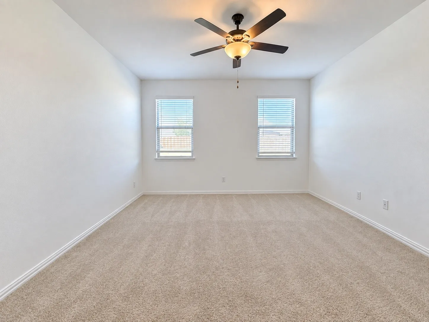 Neutral-toned carpeting, white walls, and a ceiling fan with integrated lighting