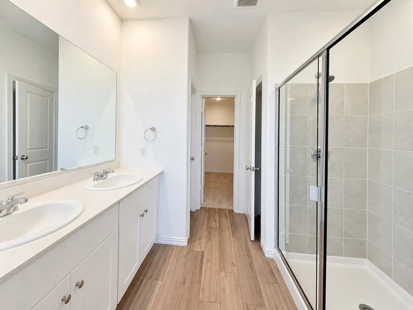 Dual vanity with white cabinetry, light-toned countertop, and undermount sinks
