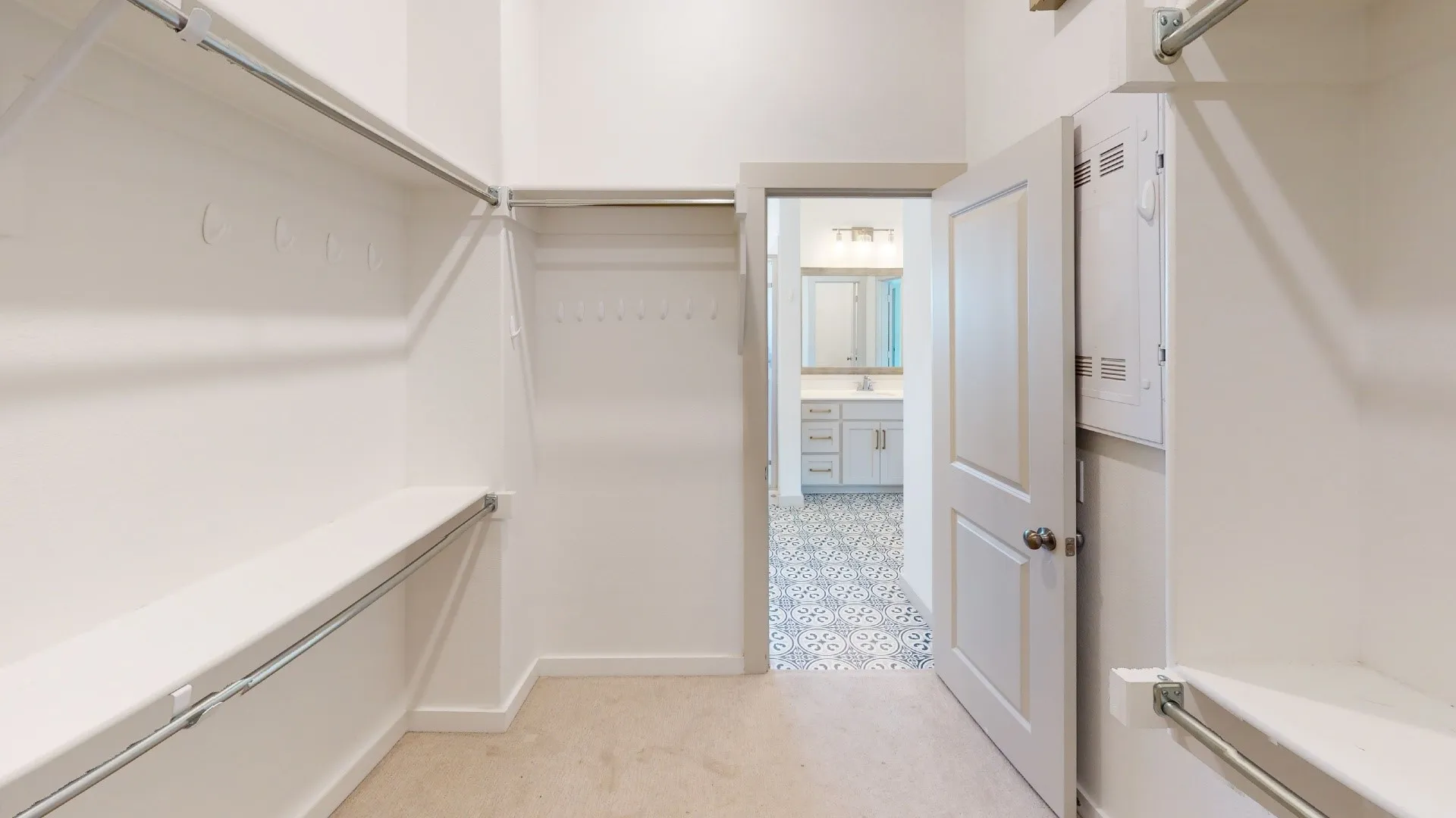 Expansive closet featuring multiple shelving units and hanging rods