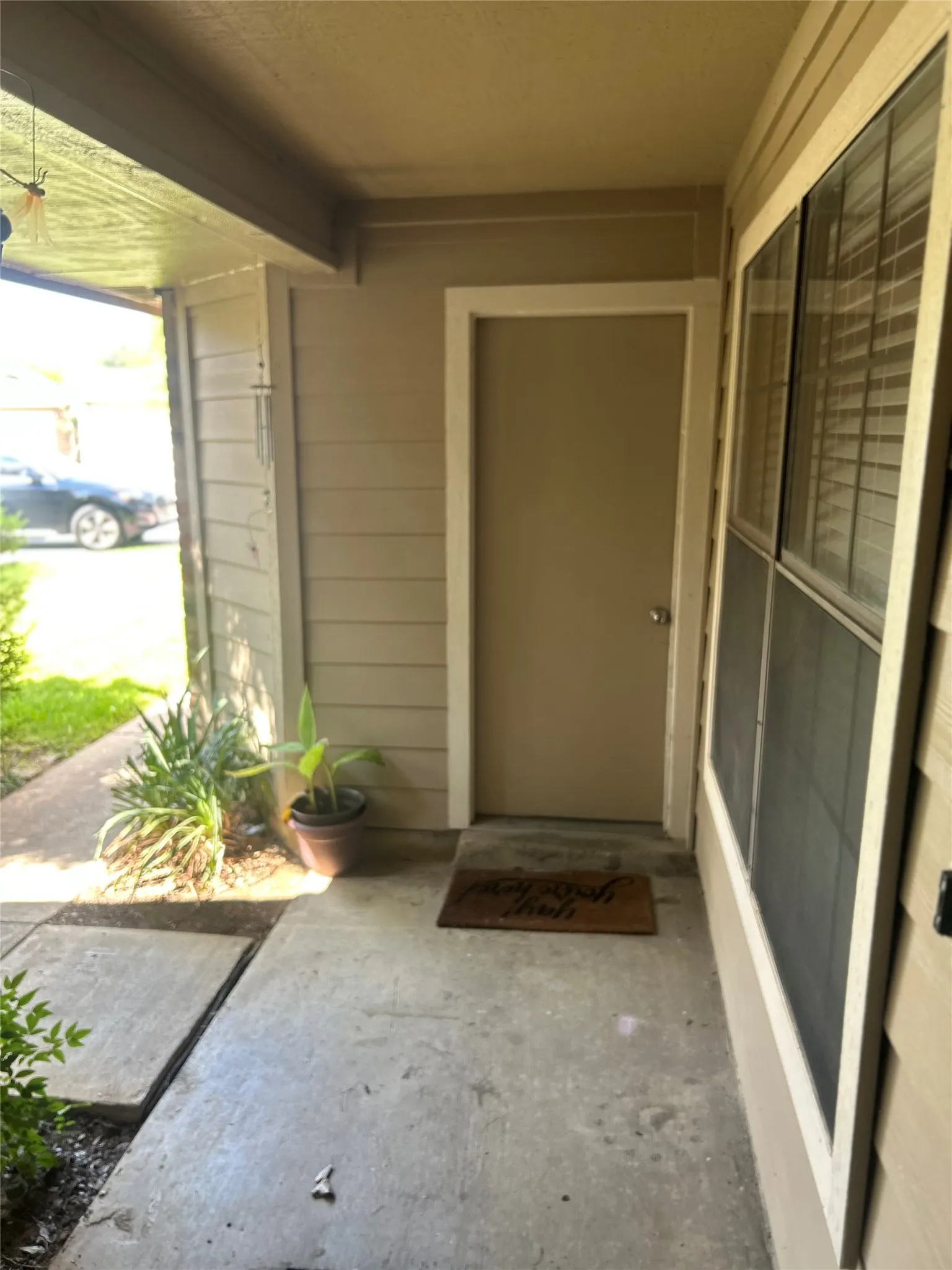 Covered entry with concrete walkway leading from front door to garage