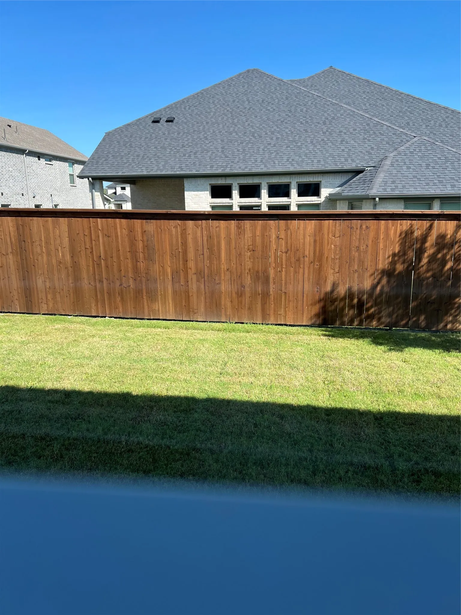 Private wood privacy fence bordering a grass yard