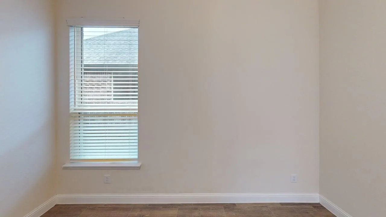 Neutral wall paint, wood-finish flooring, and a single window with blinds