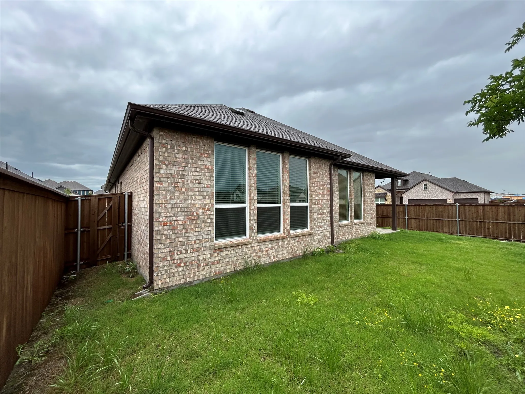 Expansive lawn area with a wood privacy fence and a gated entry