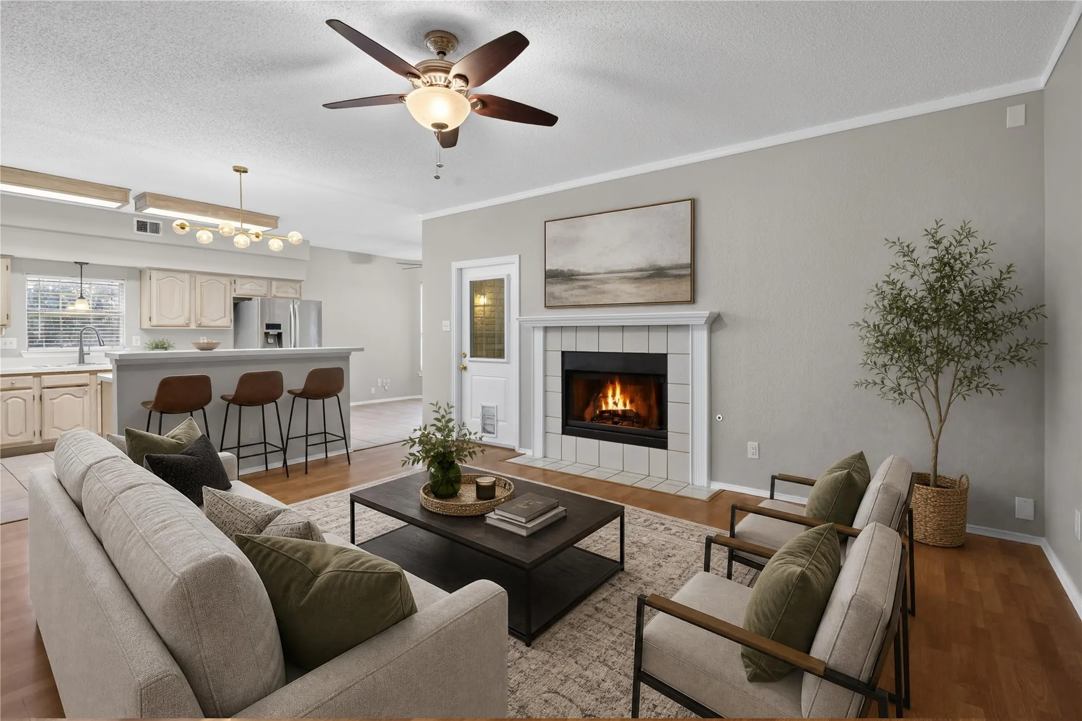 Living area featuring a fireplace with tile surround, wood-finish flooring, and a ceiling fan - virtually staged