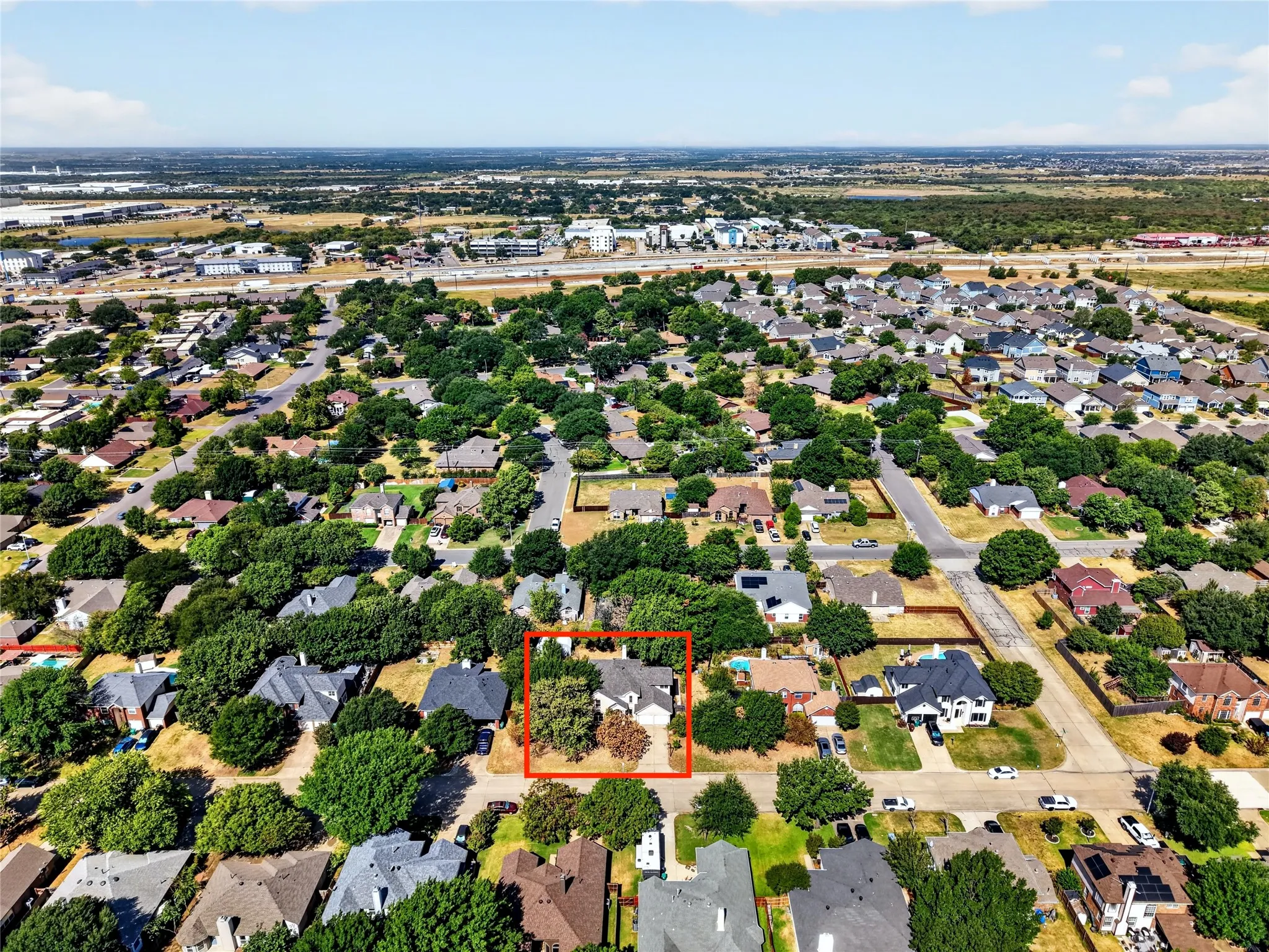 Aerial perspective of a residential neighborhood featuring mature trees and a structured street grid