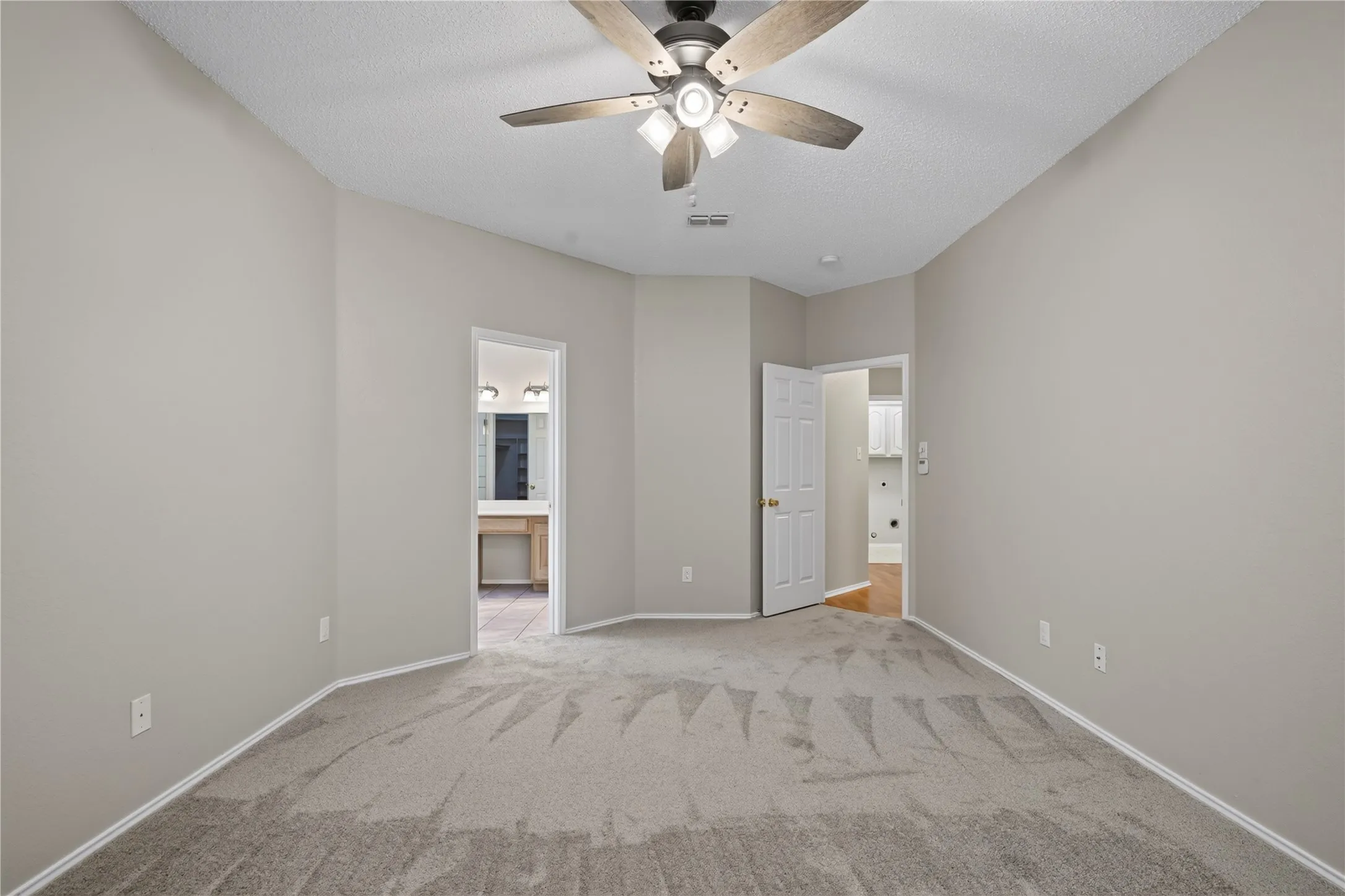 Vaulted ceiling with a ceiling fan, neutral wall paint, light gray carpet, and white trim