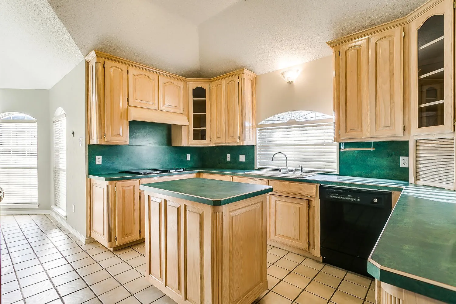 Kitchen featuring a central island, wood-finish cabinetry, integrated stovetop, and a built-in dishwasher
