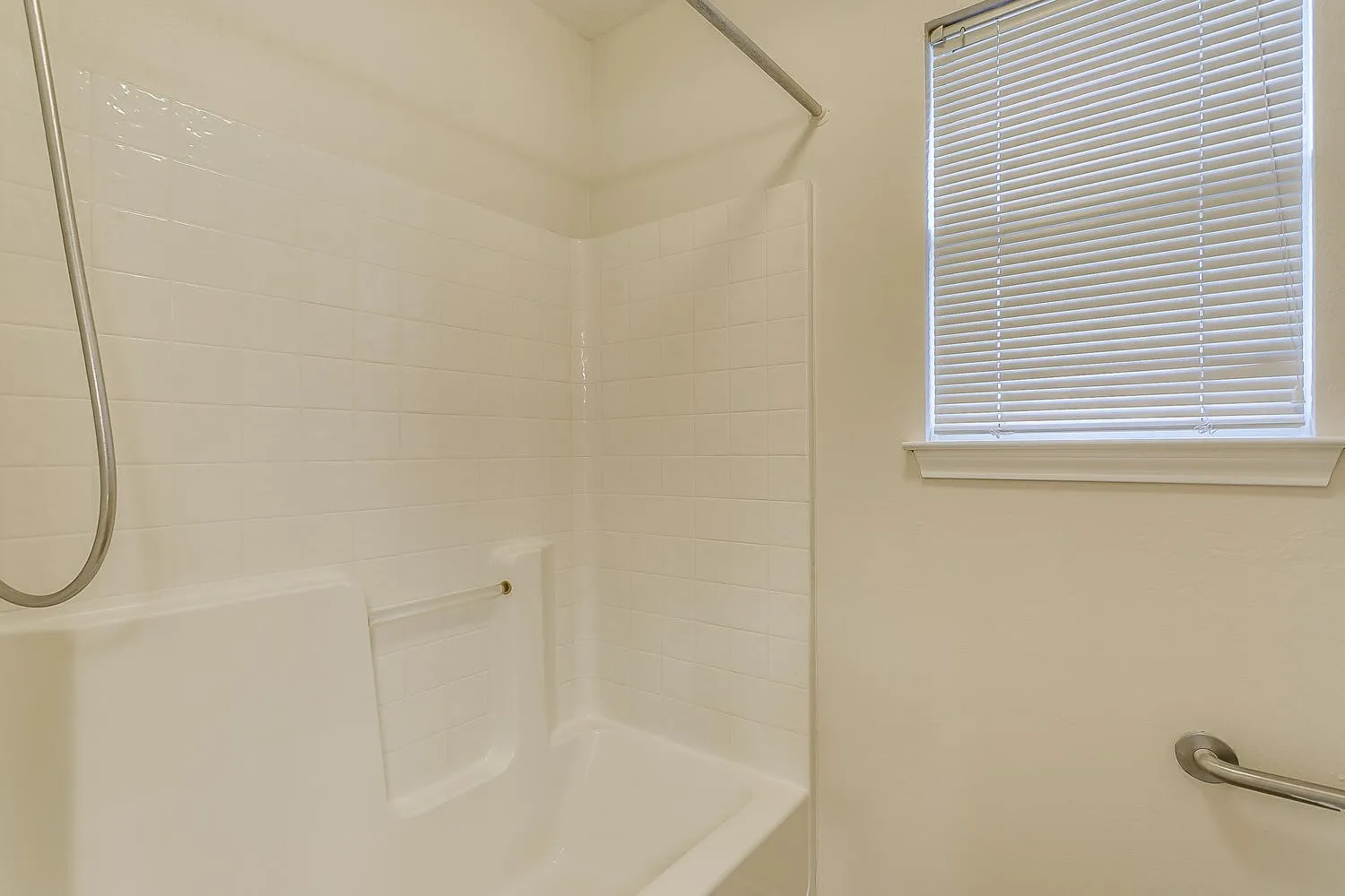 Clean, bright bathroom featuring a walk-in shower enclosure with frameless glass panels, ceramic tile surround, and chrome fixtures