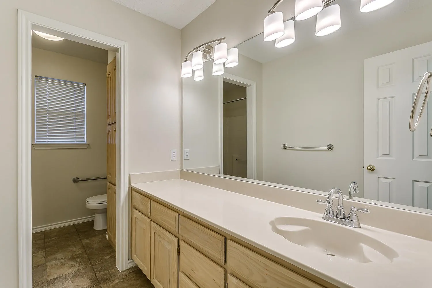 Dual vanity with an integrated sink, polished chrome faucet, and expansive wall mirror
