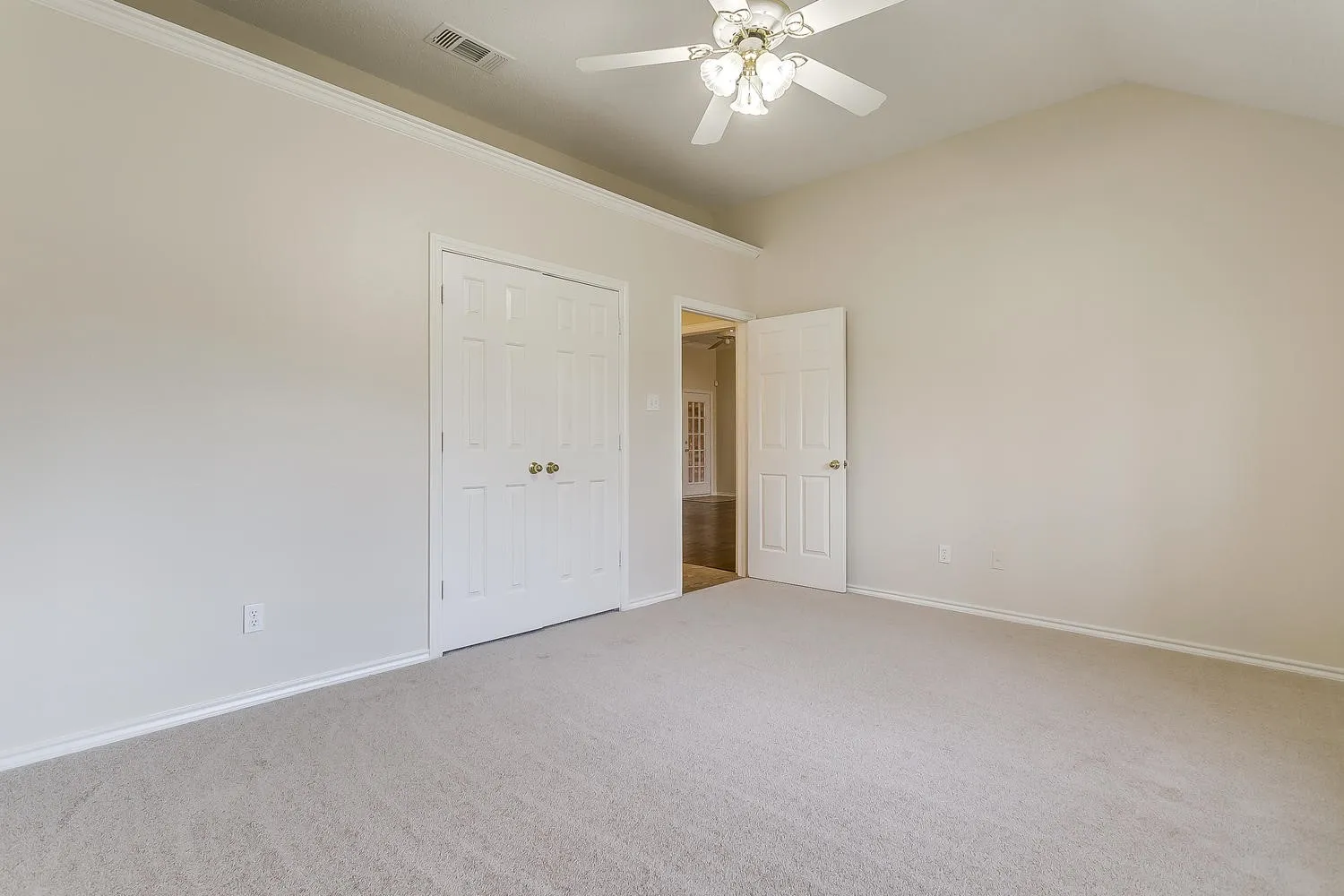 Vaulted ceiling with crown molding, carpeted flooring, and a ceiling fan with integrated lighting