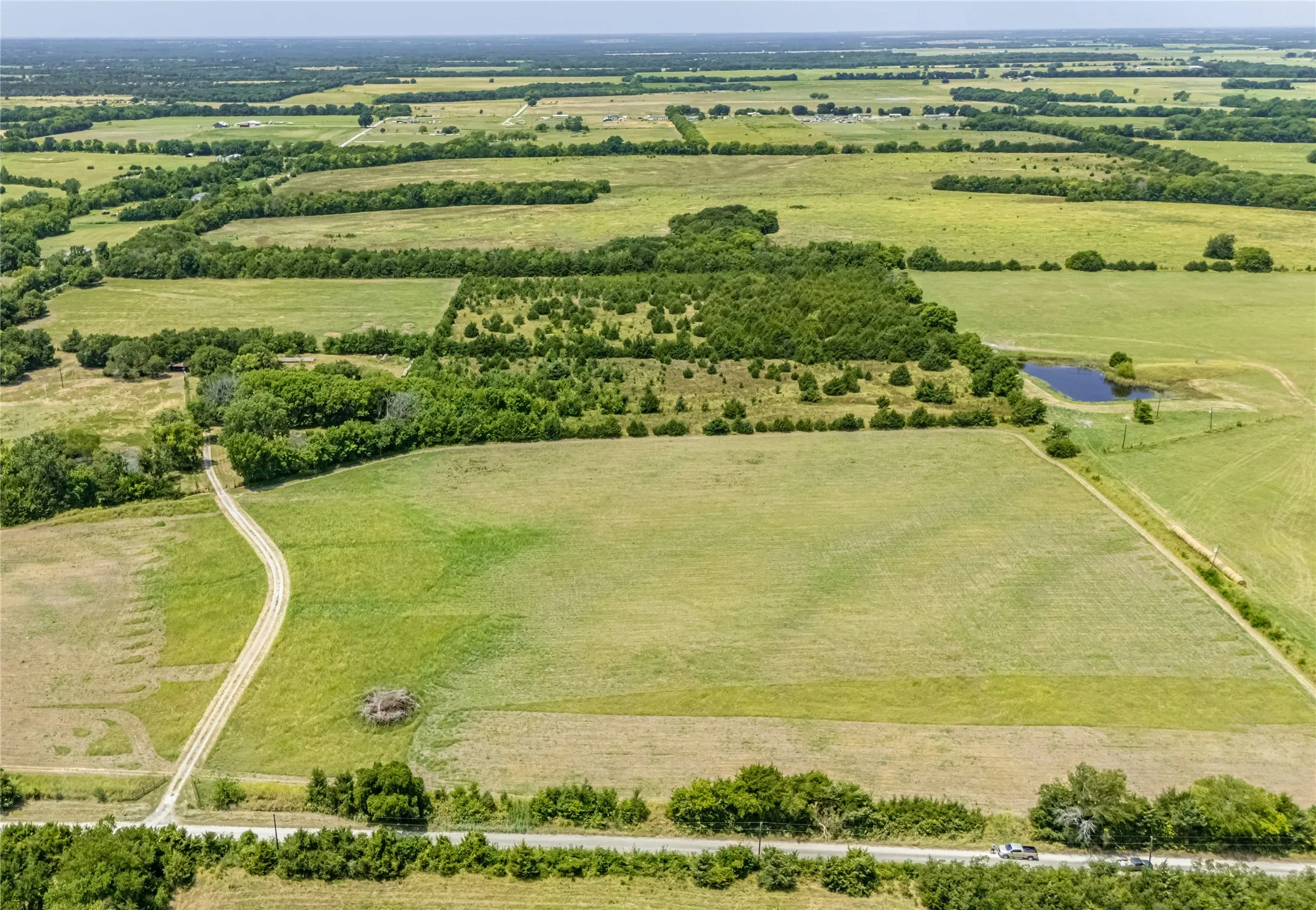 Expansive property featuring verdant fields, and established tree lines