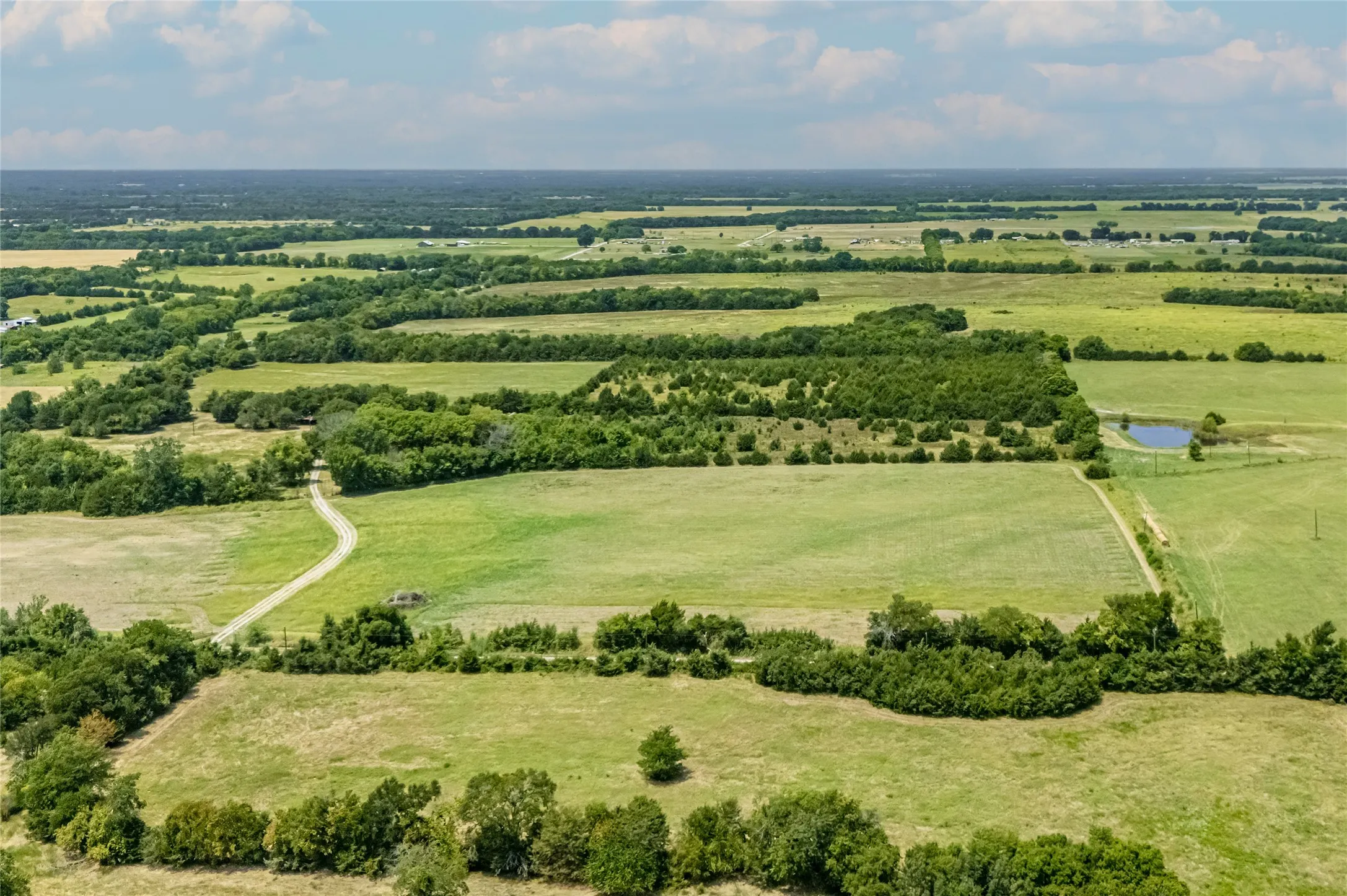 Expansive undeveloped land, 2 water meters, open pastures, and wooded areas