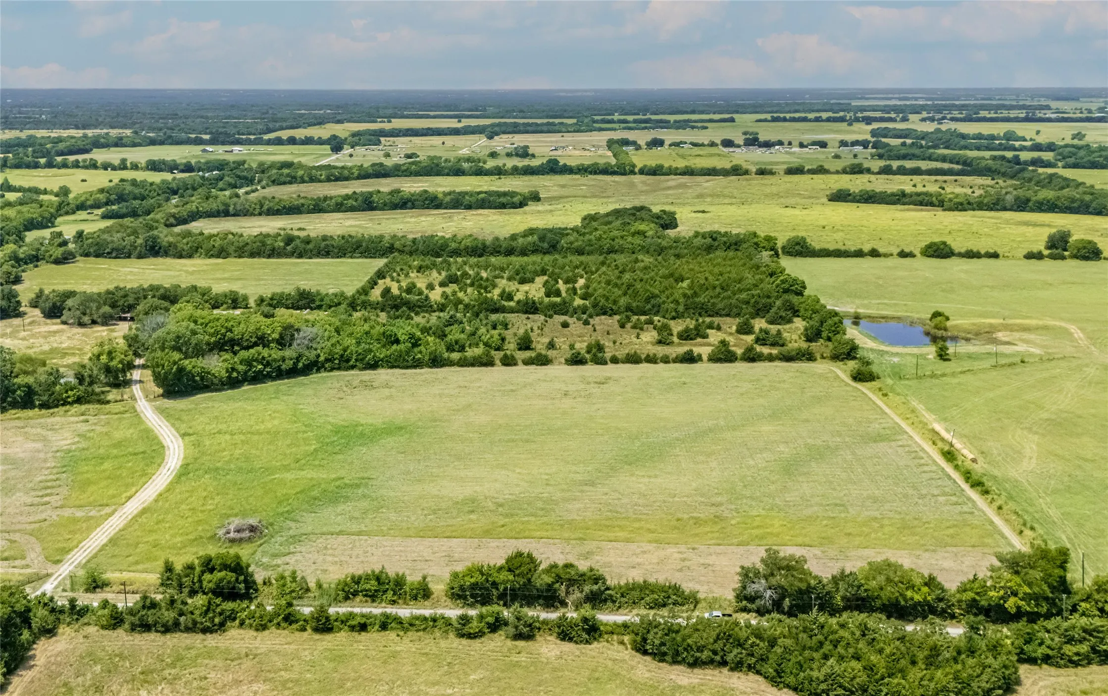 Expansive land featuring an Ag Exemption up front in the hay field.