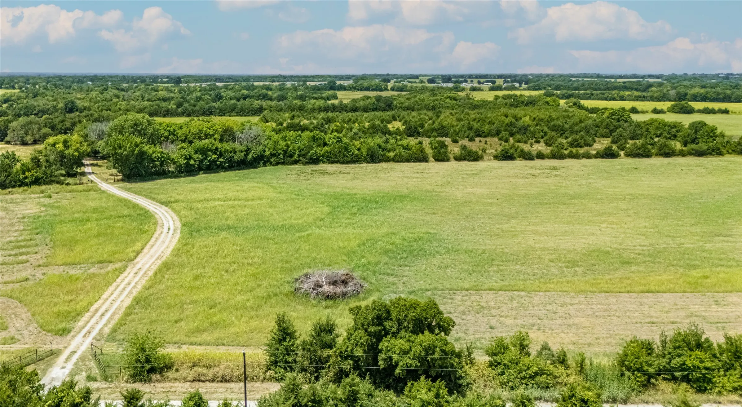Expansive green fields, mature trees.