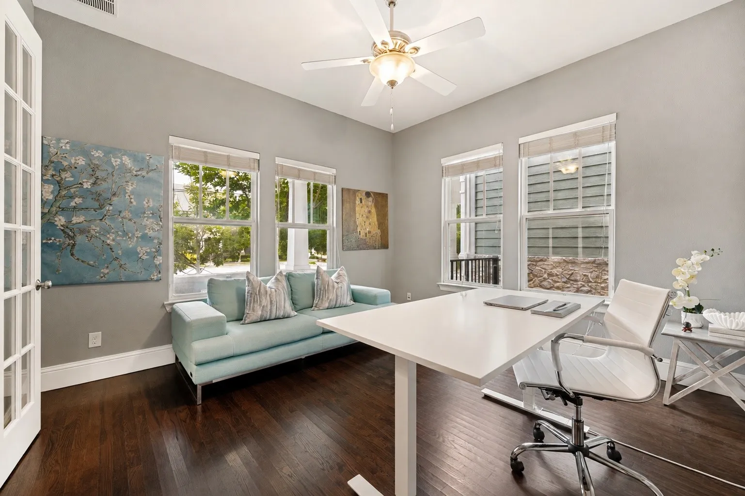 Bright study with multiple windows and hardwood floors.