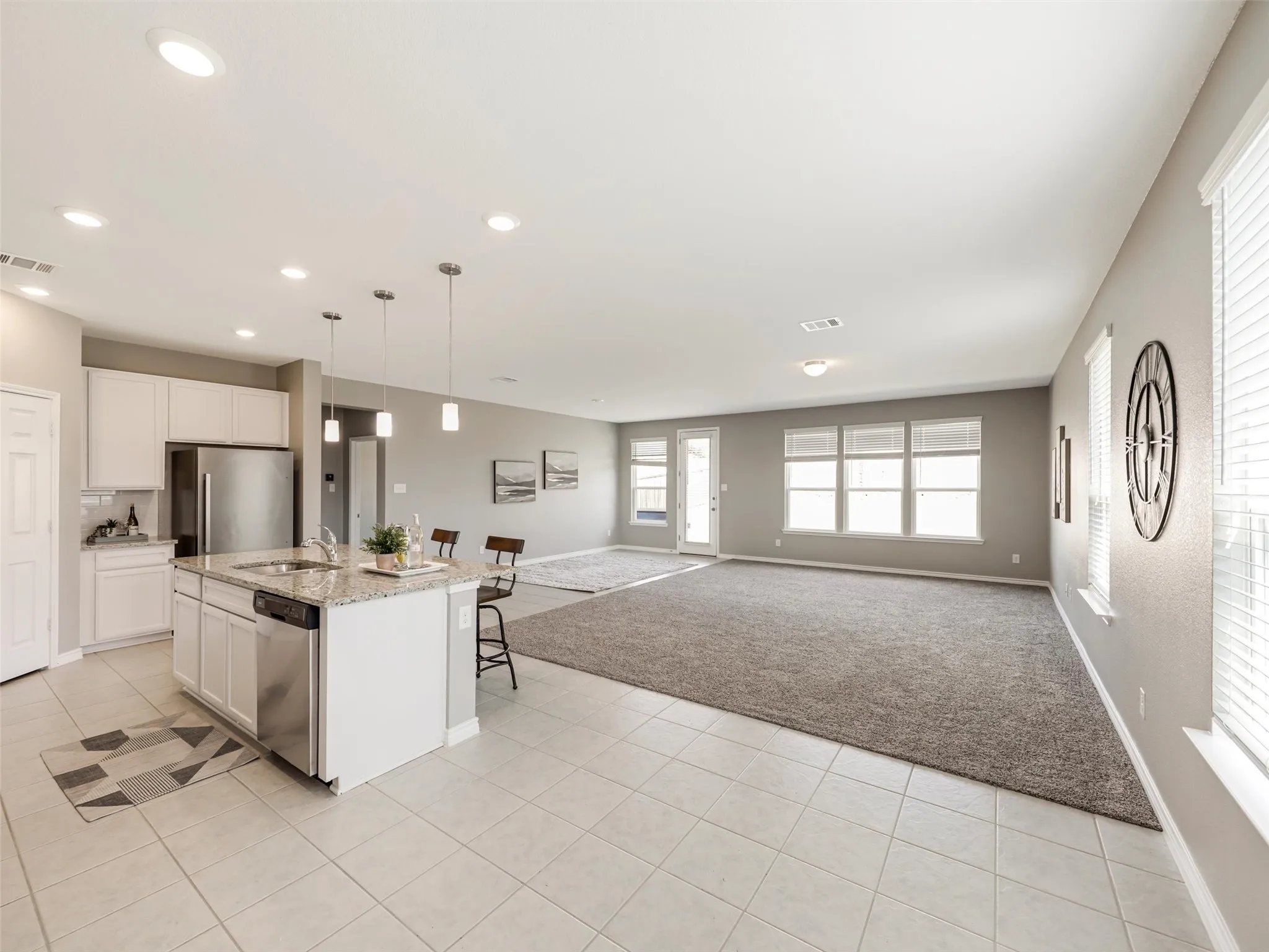 Open-concept kitchen and living area featuring abundant natural light, neutral finishes, recessed lighting, and plenty of space for everyday living and entertaining.