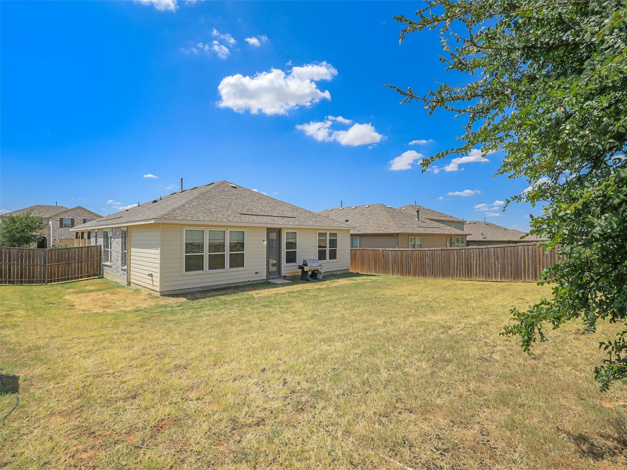 Expansive fenced backyard provides plenty of room for outdoor entertaining, gardening, recreation, or future improvements.